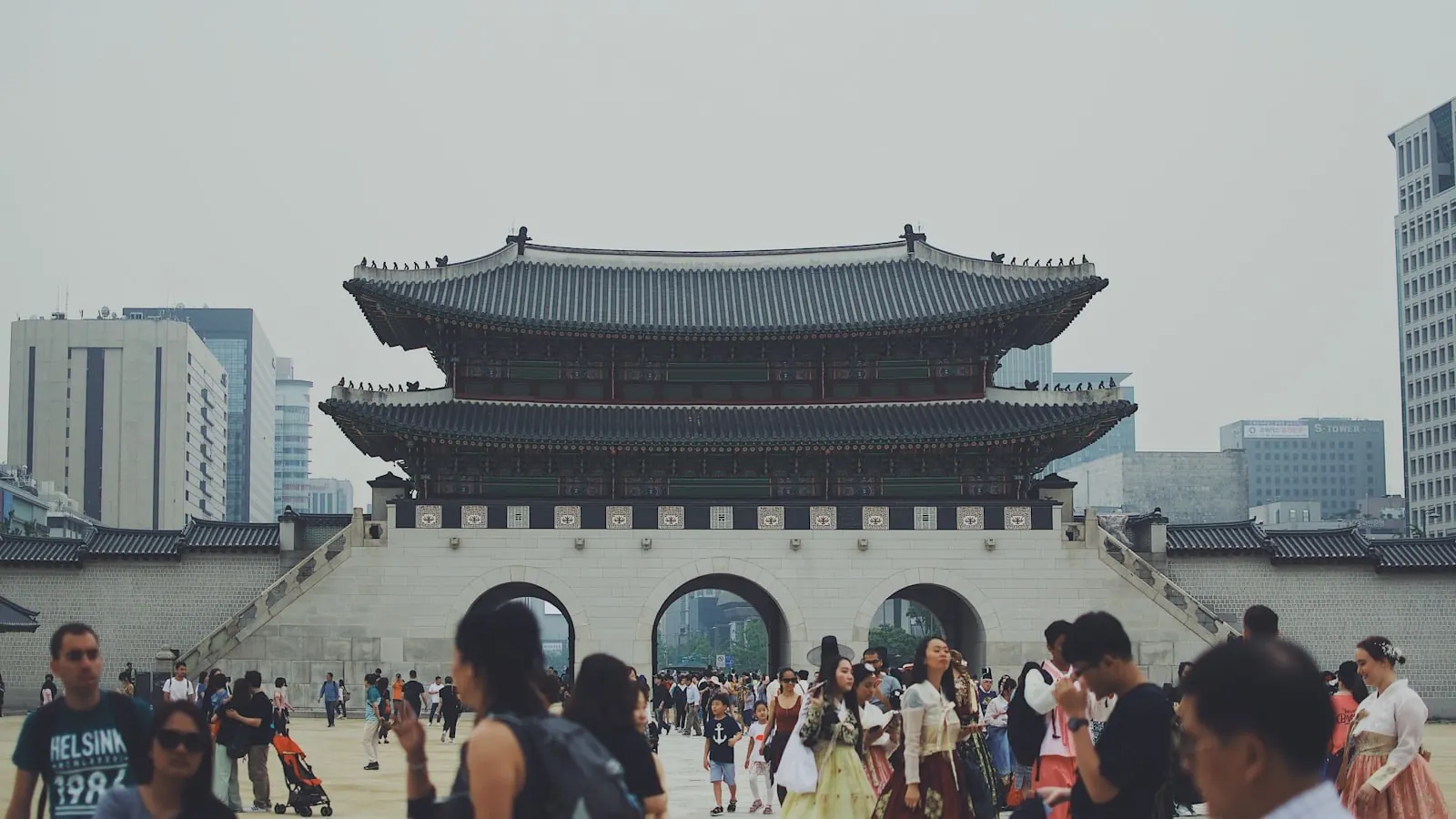 Cổng Gwanghwamun của cung Gyeongbokgung ở Seoul, du khách mặc hanbok đi lại phía trước